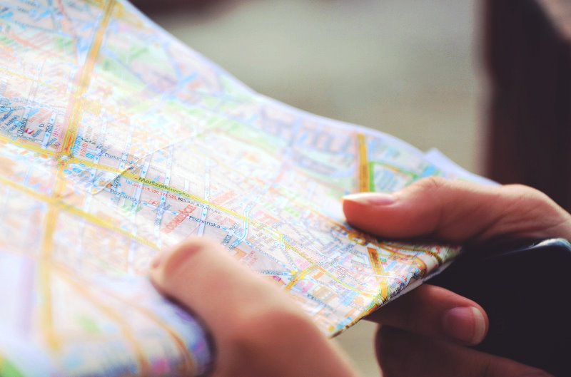 Ręce trzymające plan miasta Photo by Sylwia Bartyzel on Unsplash