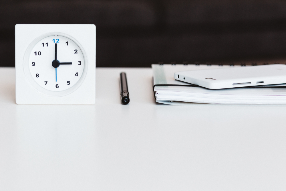 Budzik, długopis, notes i smartfon Photo by freestocks.org on Unsplash