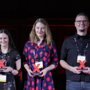 Zdjęcie dwóch kobiet i mężczyzny, trzymających statuetki Konferencji TEDxPolitechnika Gdańska 2025.